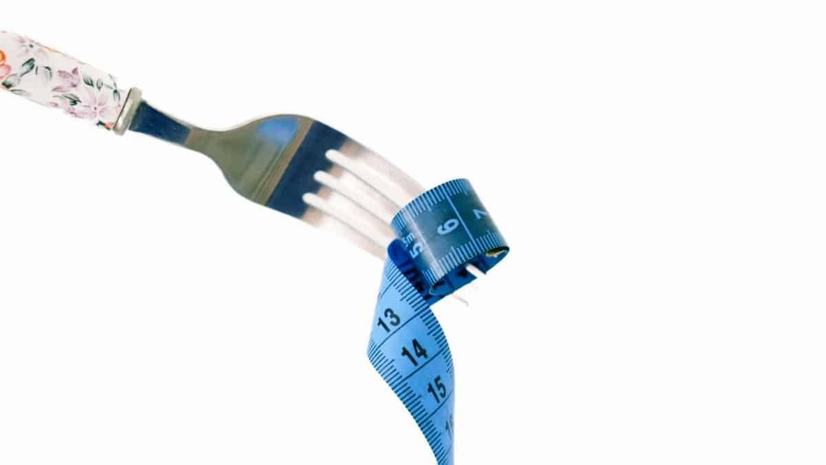 A fork twirls a blue measuring tape, symbolizing weight management and health.
