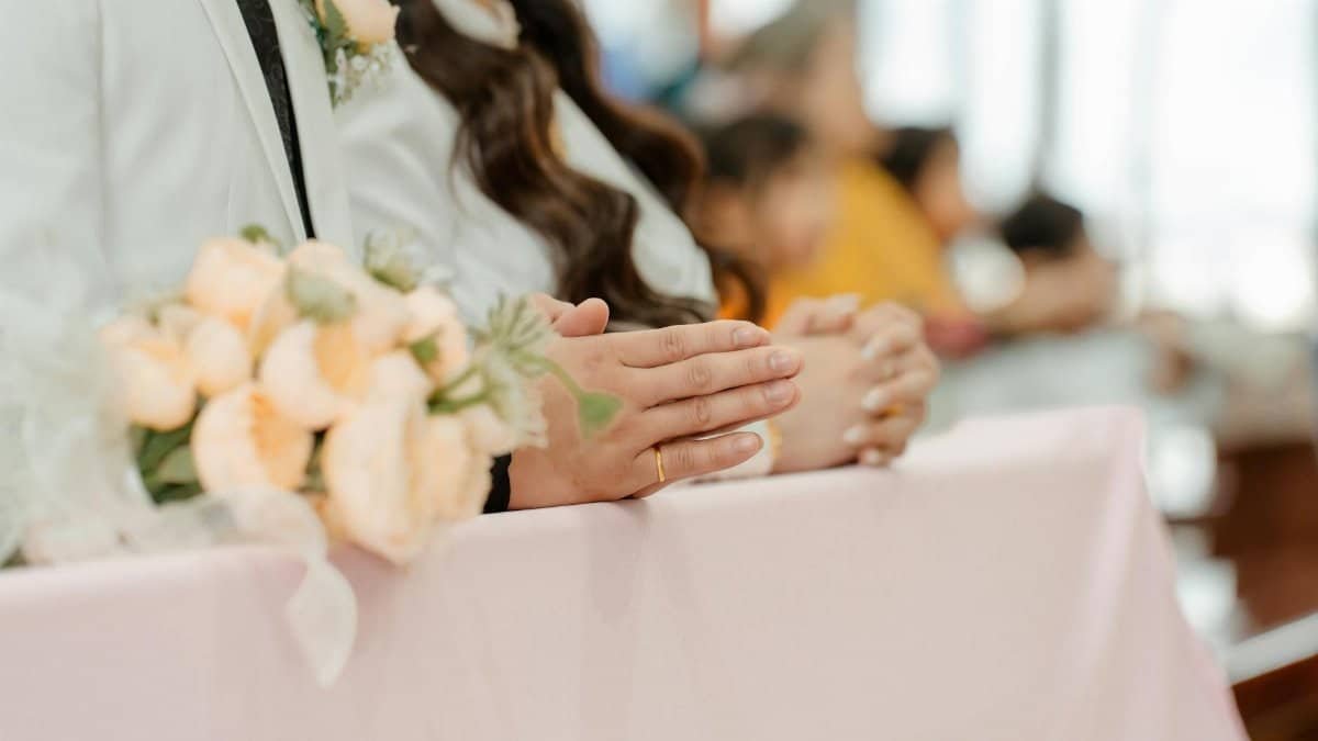 Close-up of a couple in a wedding ceremony holding a floral bouquet, highlighting details and emotions.