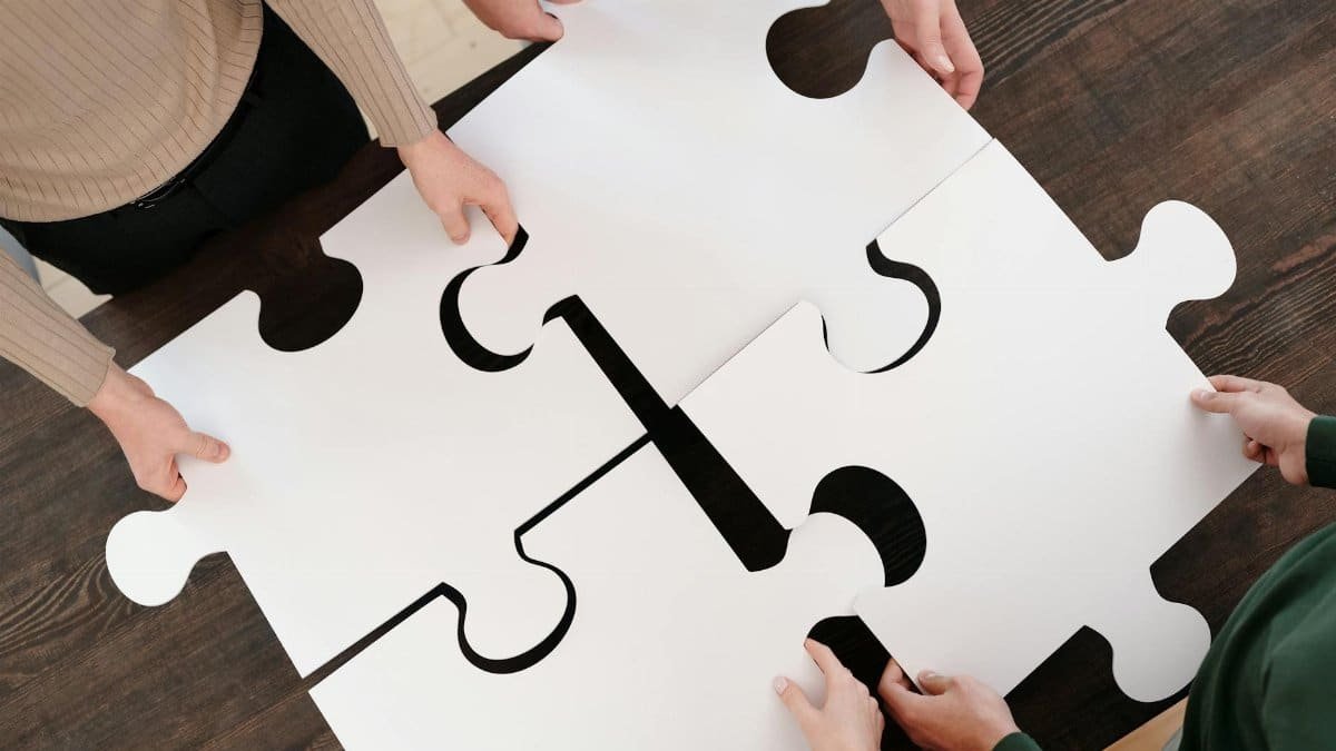 Group collaborating on assembling large puzzle pieces symbolizing teamwork and unity.