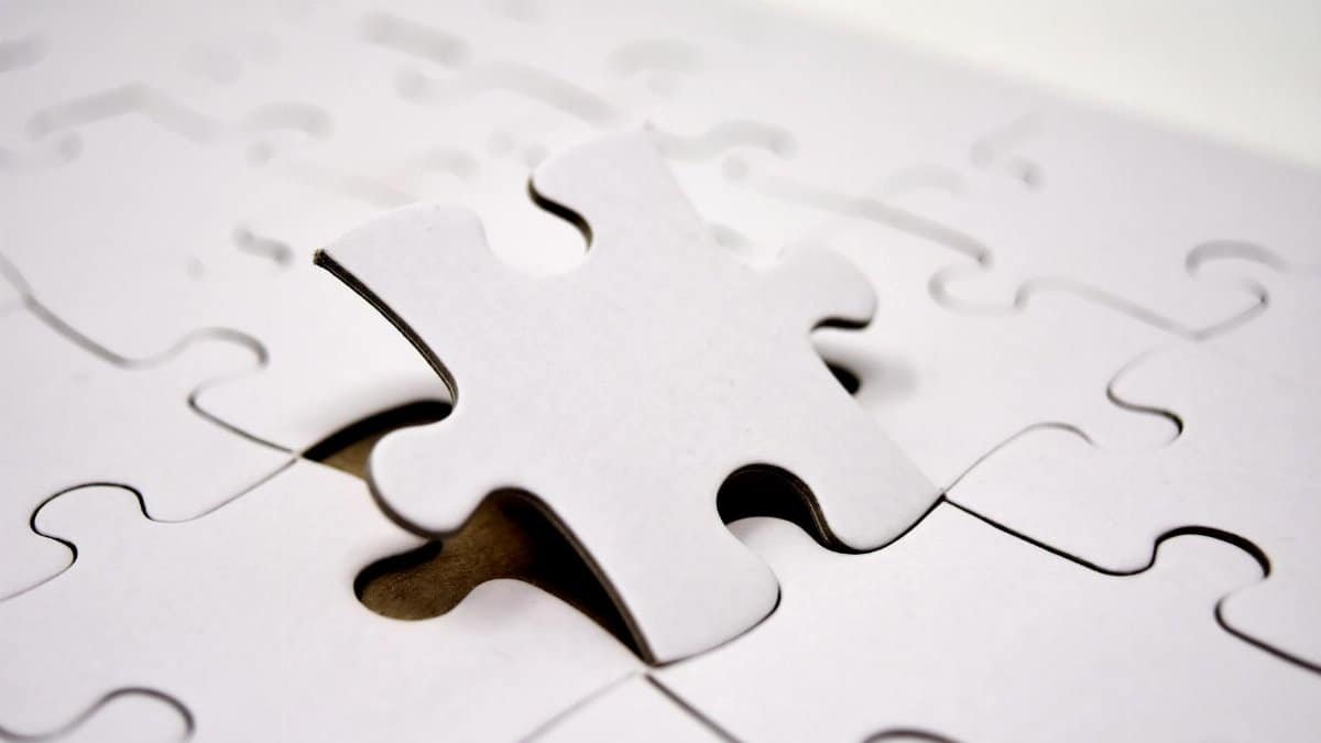 A single white jigsaw puzzle piece fitting into place. Ideal for concepts of problem-solving and solutions.