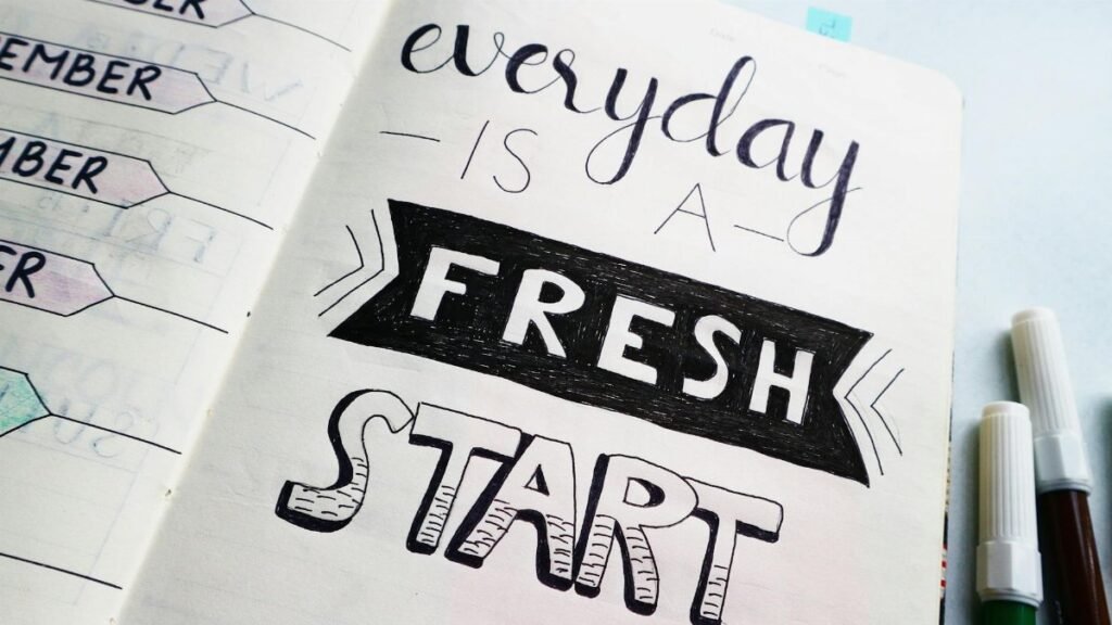 Notebook page featuring motivational quote 'Everyday is a fresh start' with colorful pens.