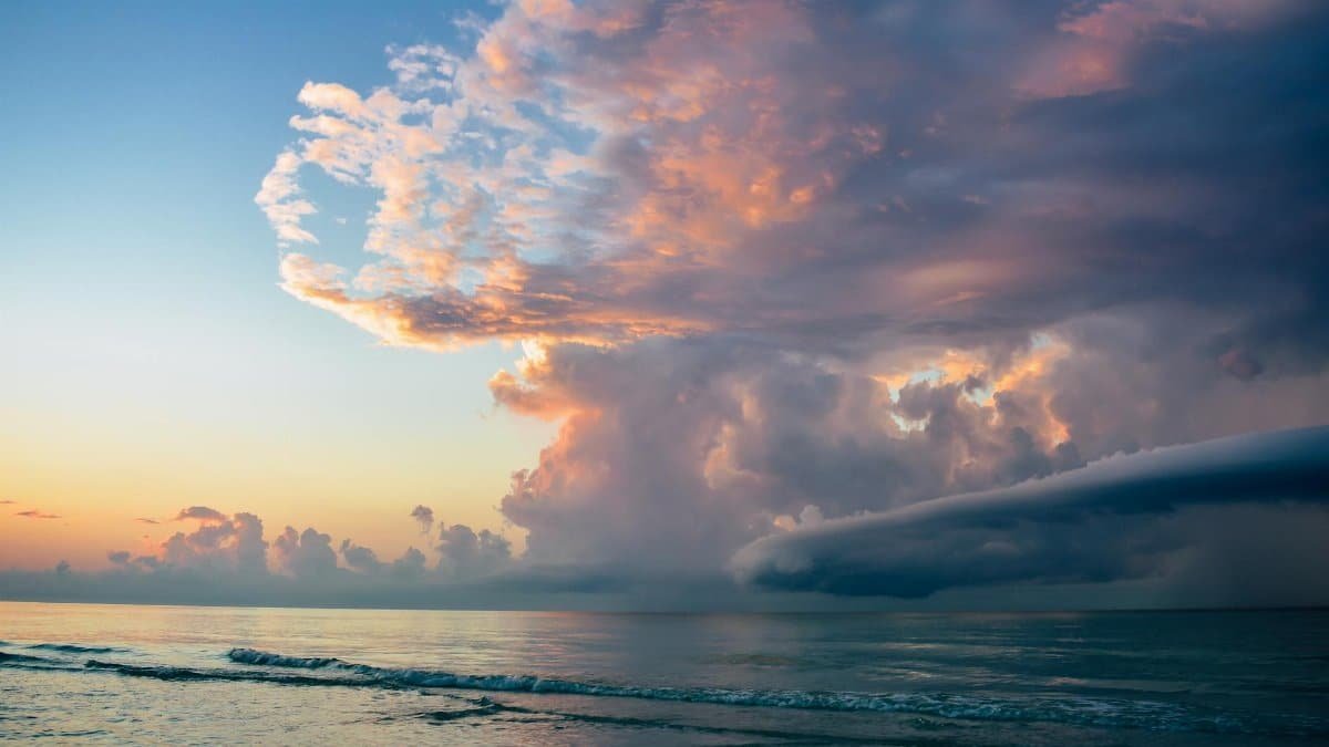 A breathtaking sunrise with dramatic cloud formations over a calm ocean, capturing nature's beauty.