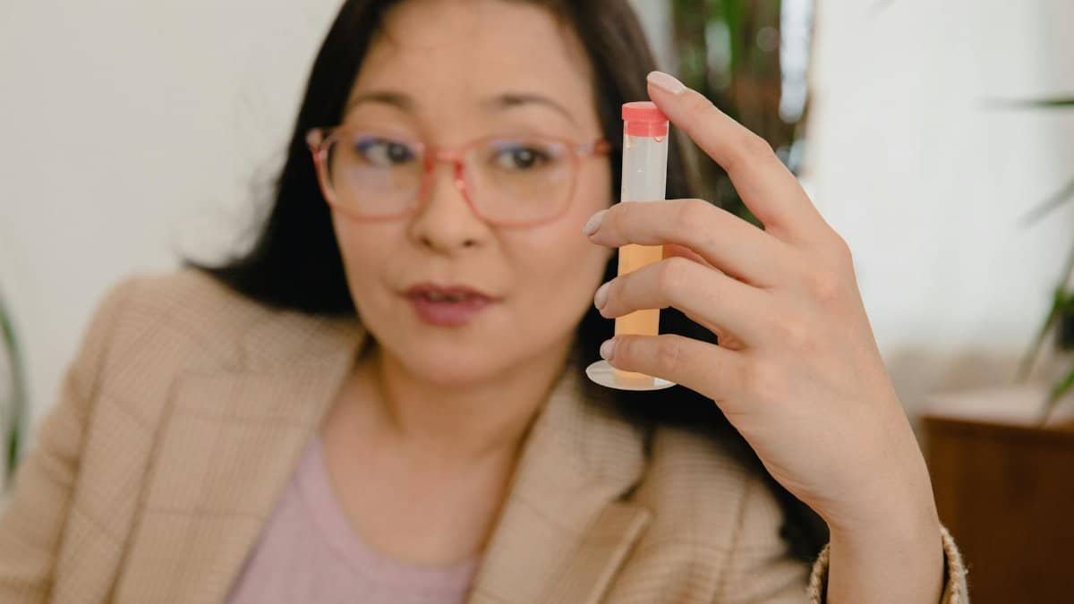 Asian businesswoman examining a test tube in a professional setting, showcasing focus and determination.