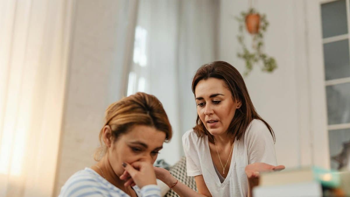Two women engaging in emotional support and communication indoors.