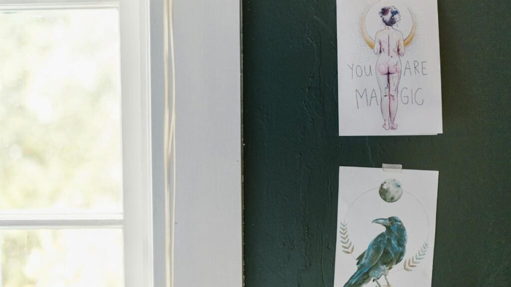 Two artistic posters with inspiring messages displayed on a dark green wall.