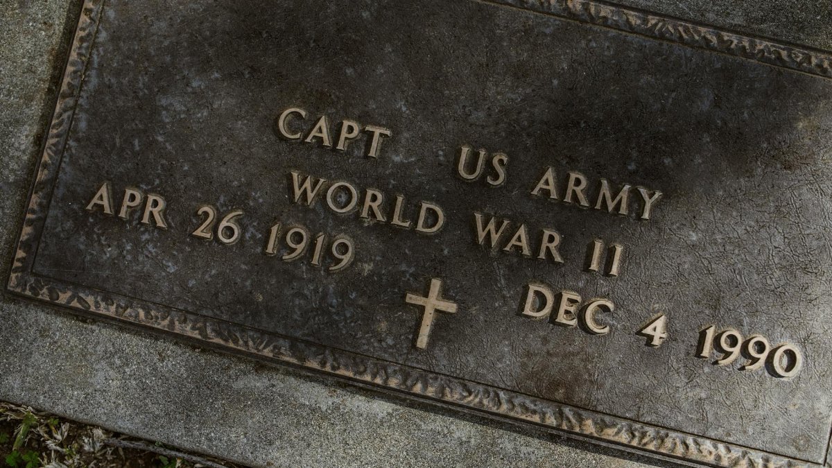 A close-up of a World War II US Army captain's gravestone with detailed inscription.