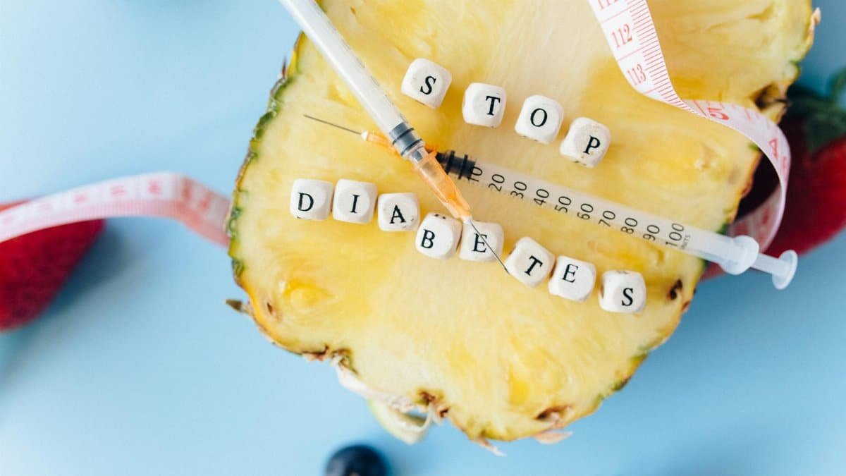 Flat lay of pineapple, syringe, and message promoting anti-diabetes awareness.