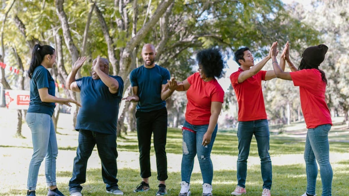 Multicultural team engaging in outdoor team building exercises in a park setting.