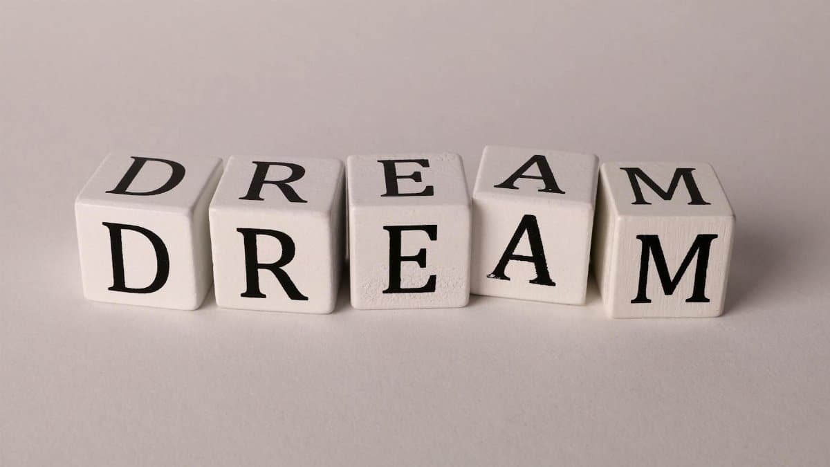 White blocks spelling 'DREAM' on a neutral background. Perfect for inspiration themes.