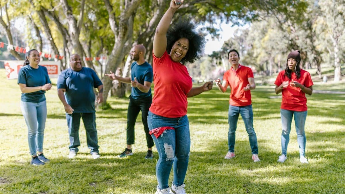 A diverse group of adults bonding and having fun during outdoor activities in the park.