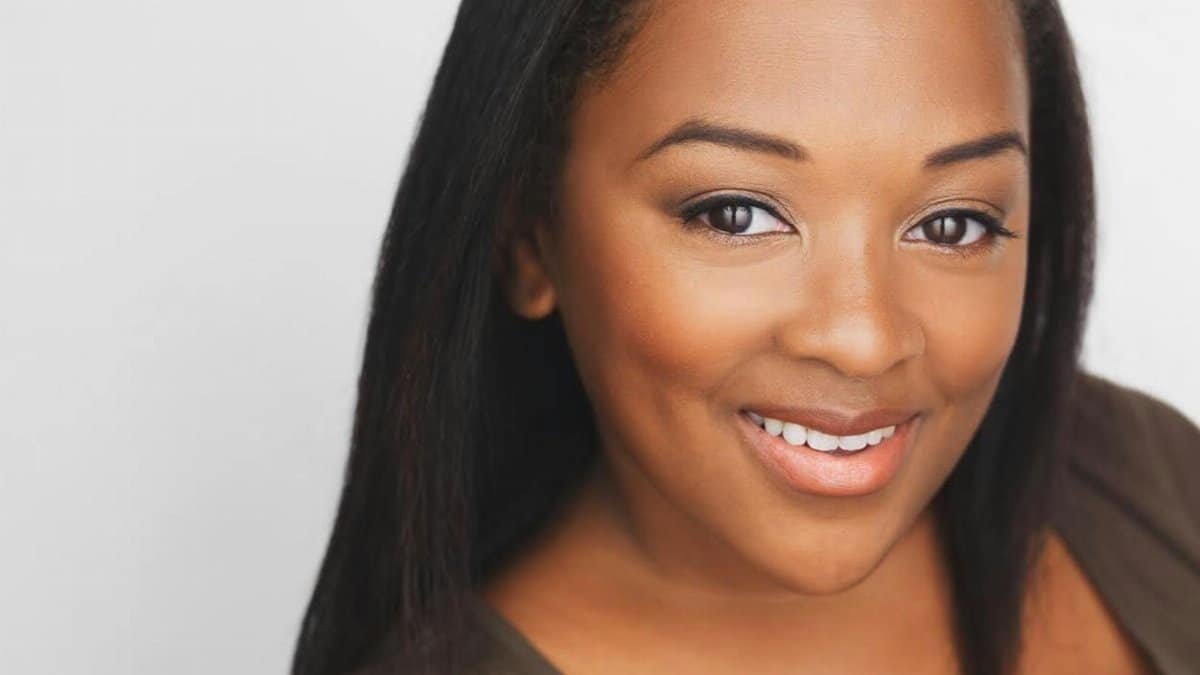 Portrait of a young woman with a confident smile and natural makeup.