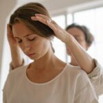 A serene moment of relaxation as a woman receives a gentle massage in a sunlit room.