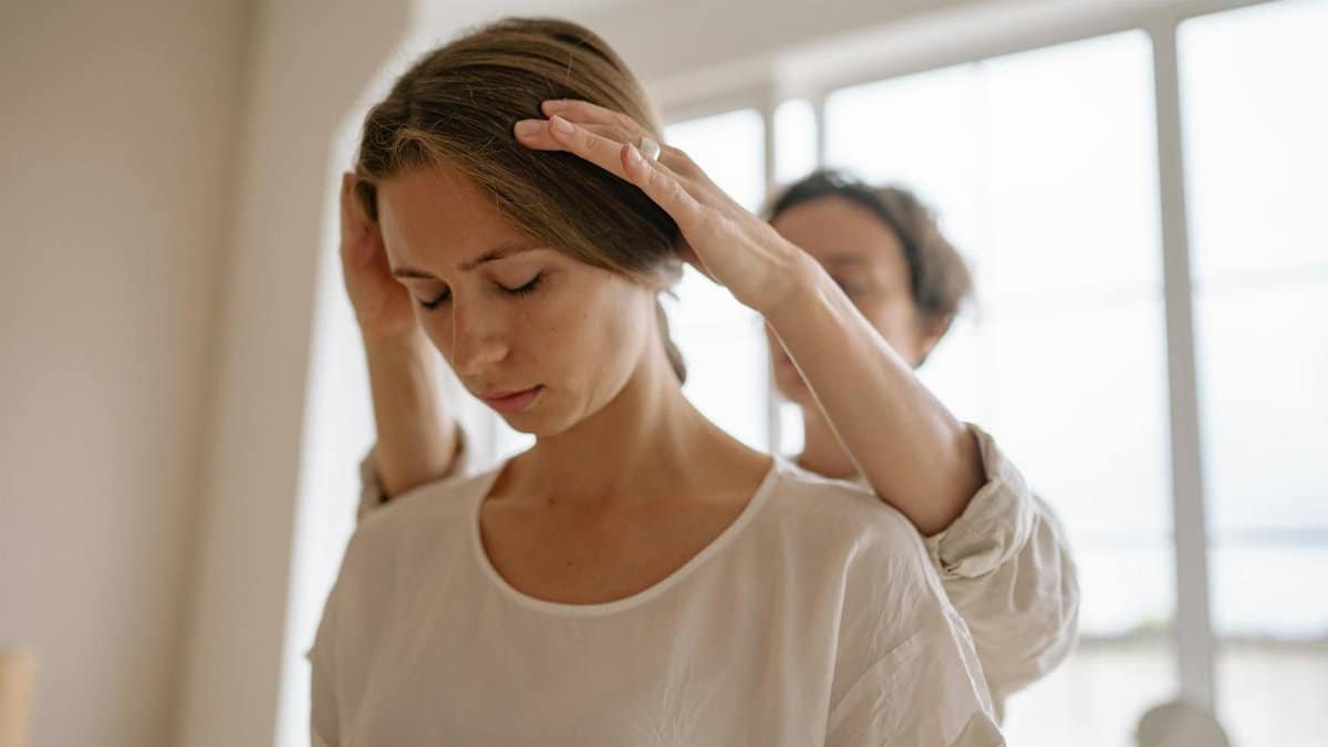A serene moment of relaxation as a woman receives a gentle massage in a sunlit room.