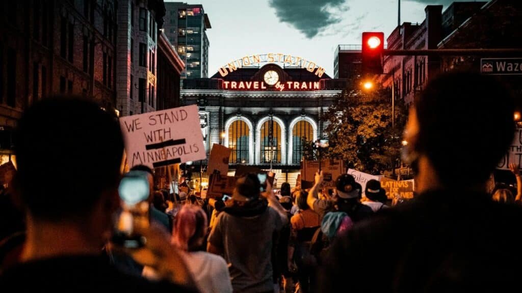 A protest at Denver's Union Station with signs supporting Minneapolis, captured at night.
