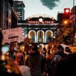 A protest at Denver's Union Station with signs supporting Minneapolis, captured at night.