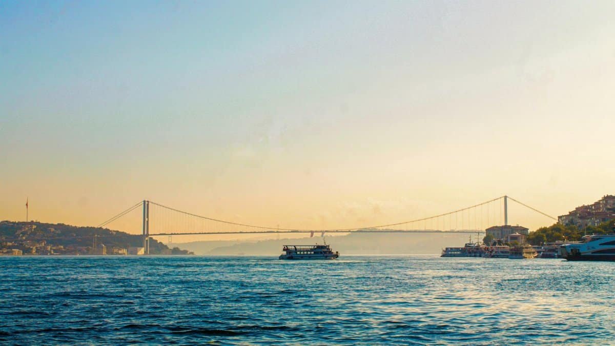 View of the Bosphorus Strait and bridge during twilight in Istanbul, featuring ferry boats.