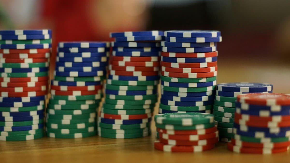 A close-up view of colorful stacked poker chips on a wooden table, perfect for casino themes.