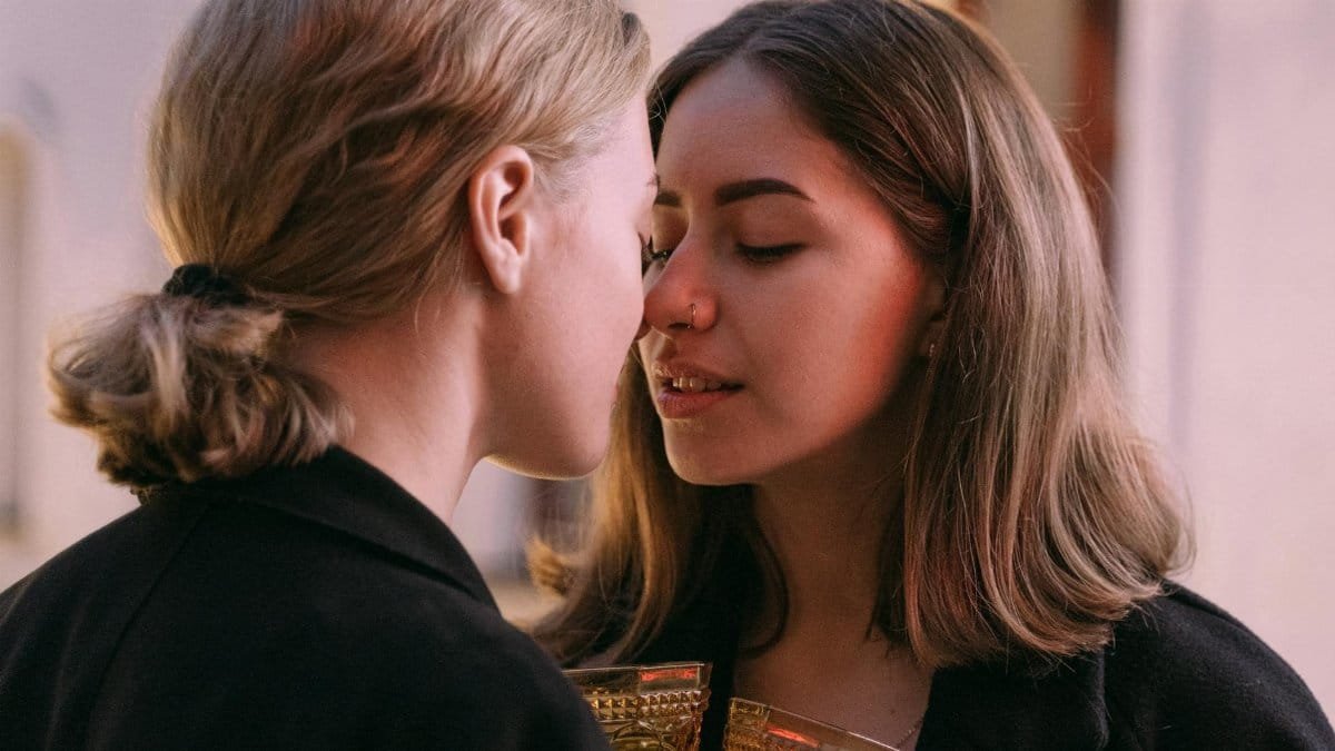 Two women share an intimate moment during a romantic evening. Perfect for lifestyle and pride themes.