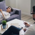 A woman engaged in a therapy session with a psychologist in a modern office setting.