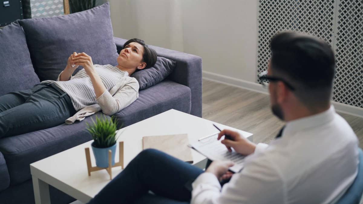 A woman engaged in a therapy session with a psychologist in a modern office setting.