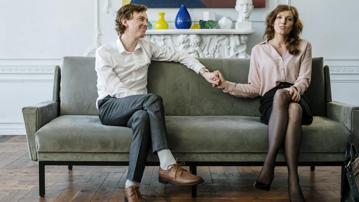 A couple in a therapy session holding hands, conveying support and connection.