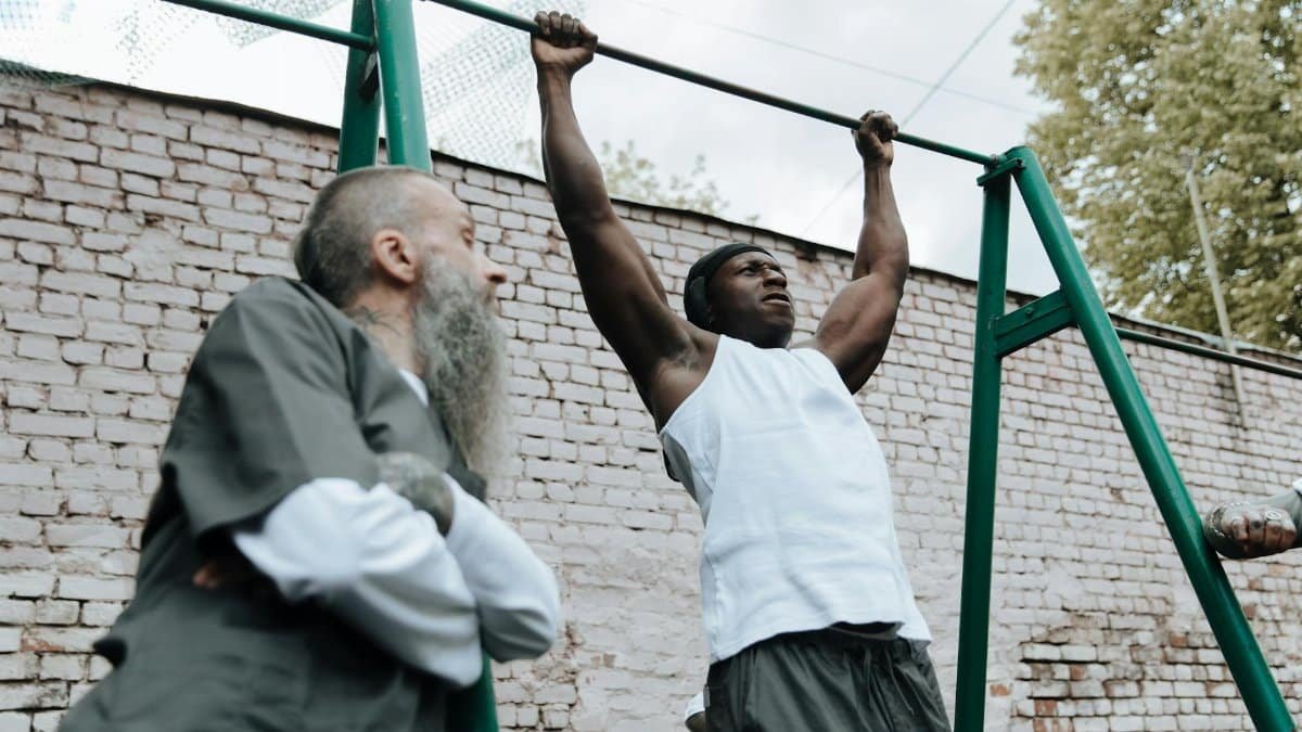 Men exercising in a prison yard showcasing strength and fitness activities.