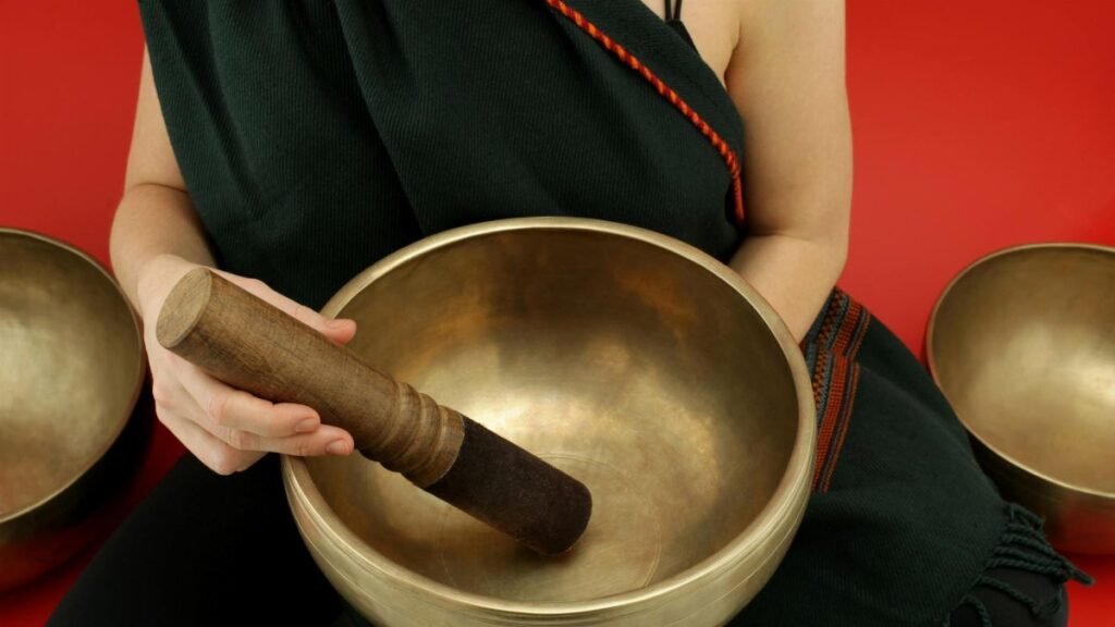 Close-up of a person holding a Tibetan singing bowl during meditation for relaxation and healing.
