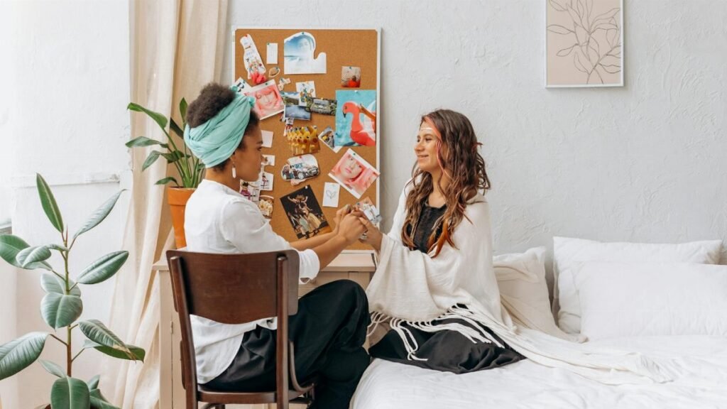 Two women sharing a mindful and spiritual moment in a cozy, indoor setting, promoting wellness and connection.