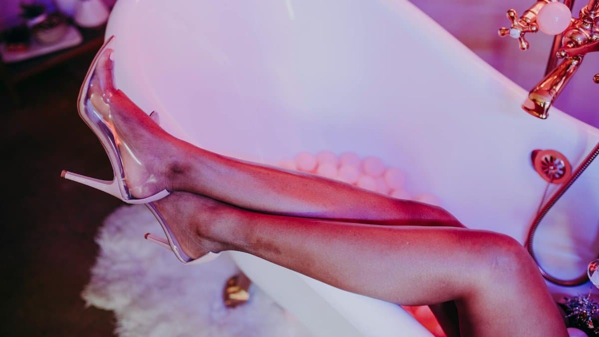 Trendy high heels and relaxed legs in a stylish bathtub setting. Modern luxury vibe.