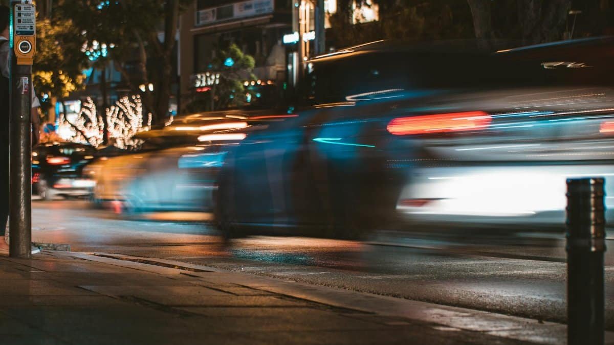 Long exposure capture of urban traffic showcasing light streaks and busy city life at night.