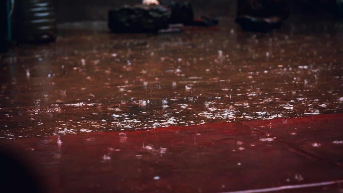 Raindrops splashing on a street surface, creating a reflective wet scene in Kiambu, Kenya.