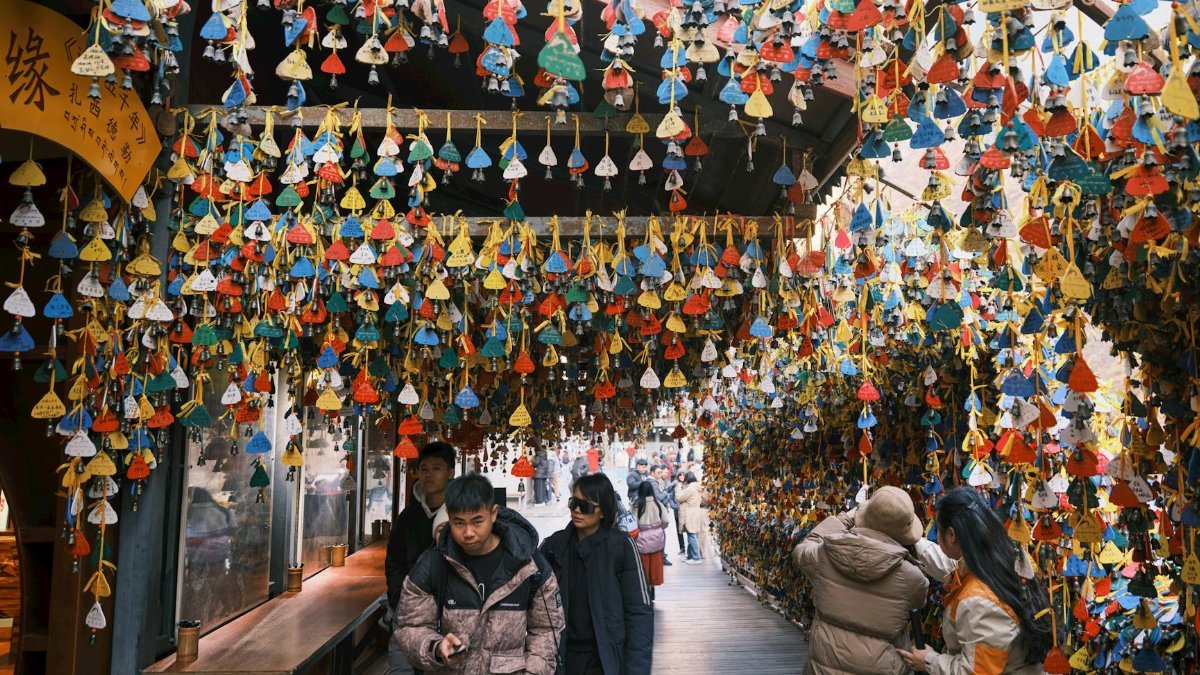 Crowded market scene with vibrant hanging wishing bells, capturing cultural ambiance.