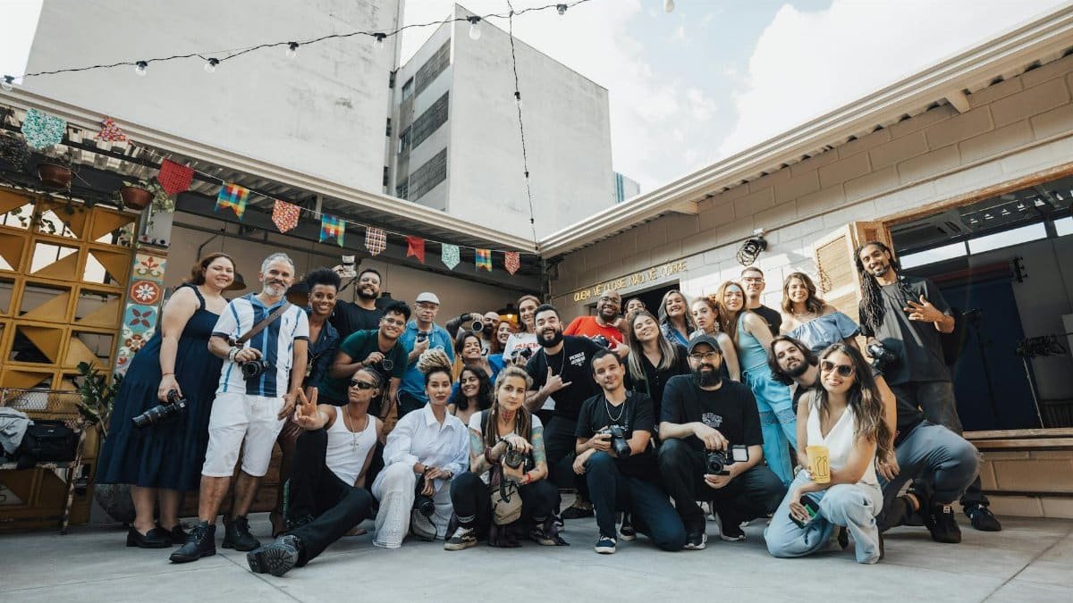 Diverse group of photographers posing together in São Paulo, showcasing creativity and community.