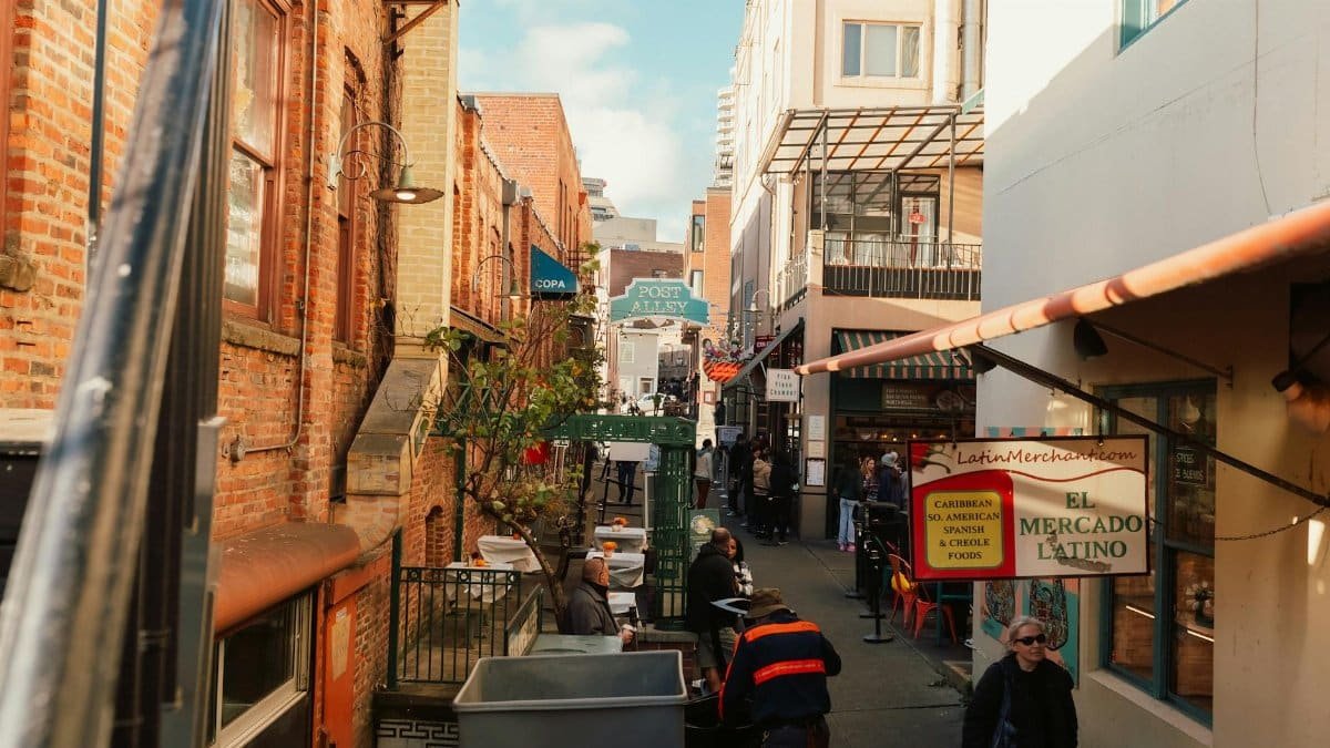 A vibrant view of Post Alley in Seattle, showcasing Latin American shops and lively foot traffic.