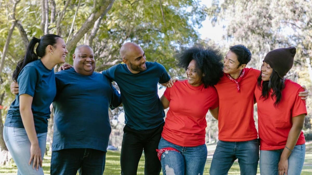 Six friends enjoy bonding outdoors, showcasing diversity and happiness.