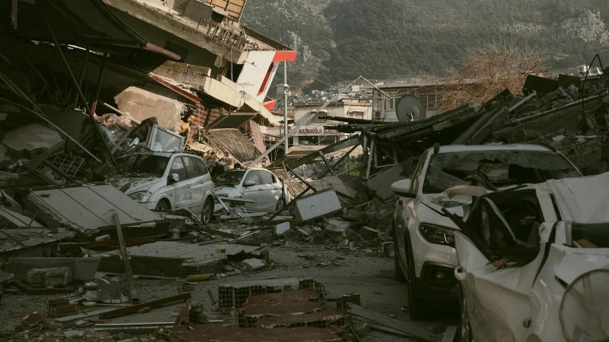 Severe earthquake damage in Antakya, Türkiye, with collapsed buildings and cars.