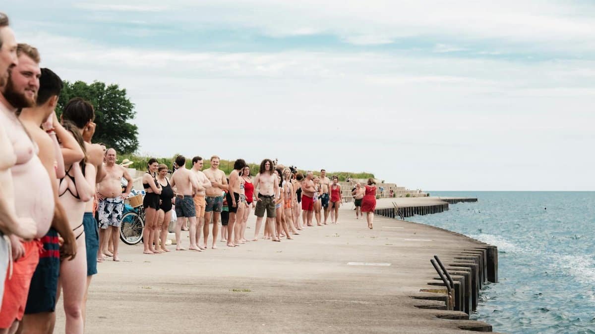 A large group enjoys a summer day on the pier at Chicago's lakefront, embracing leisure and community.