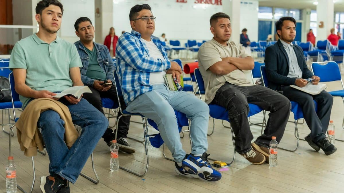 A diverse group of adults in a Christian workshop in Ciudad de México focusing on worship and learning.