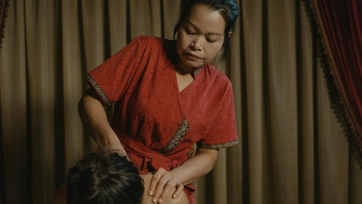 Woman performing a professional massage at a spa, promoting relaxation and relief.