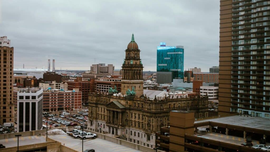 Aerial view of Detroit city showcasing historic and modern buildings under a cloudy sky.