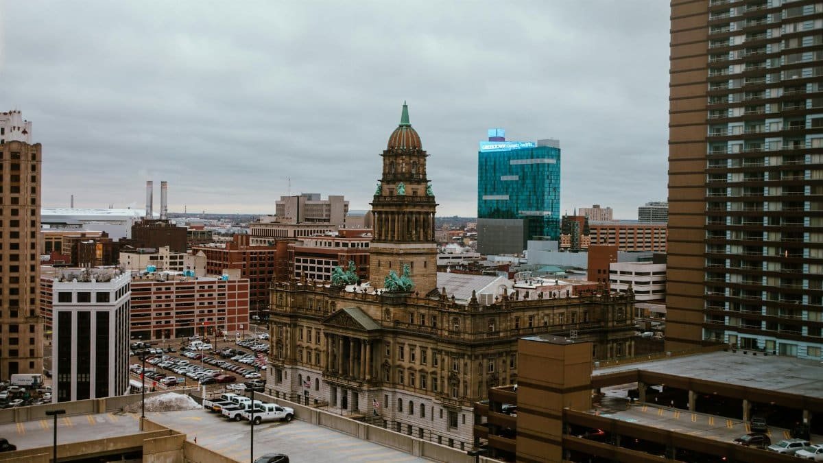 Aerial view of Detroit city showcasing historic and modern buildings under a cloudy sky.