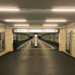 Deserted hallway of a Berlin subway station with yellow tiles and bright lighting.