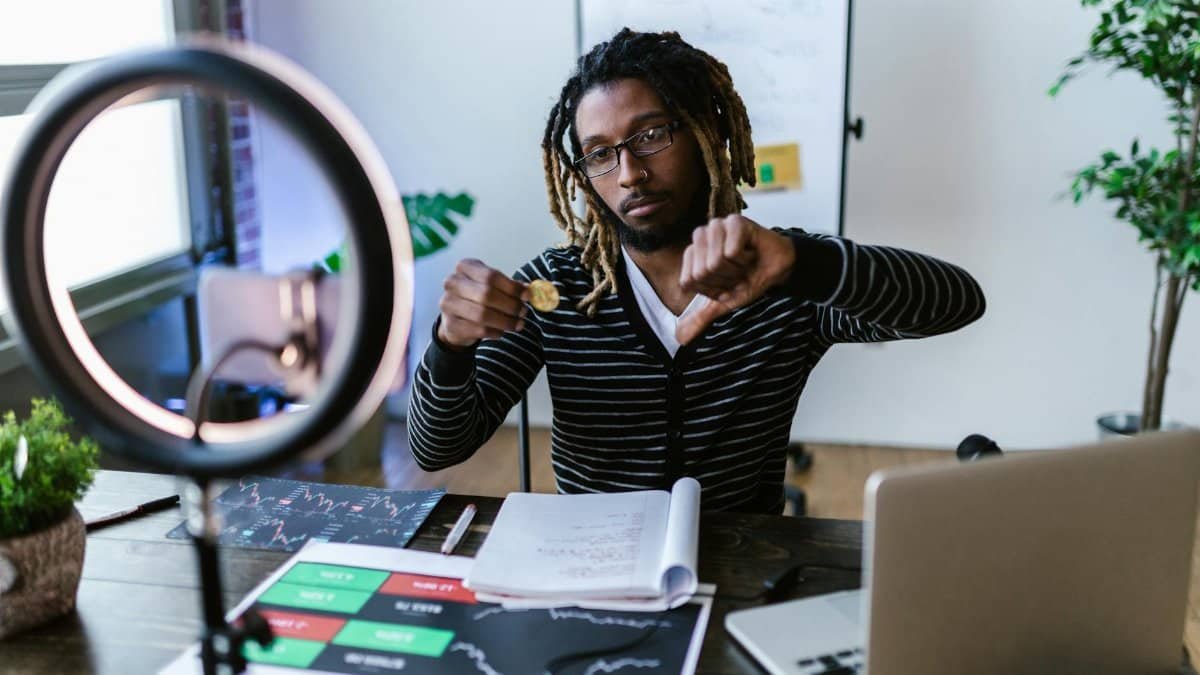 Adult man showing dislike for cryptocurrency investment while in a modern office setting.