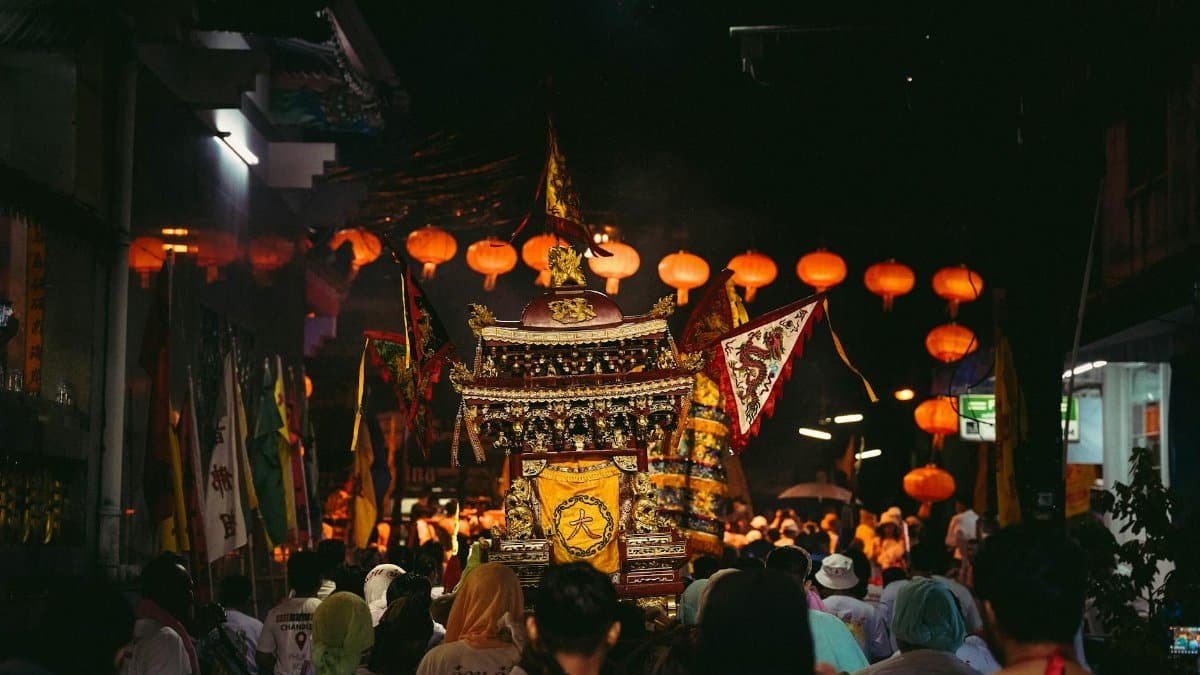 A colorful religious procession with lanterns and decorations in Phuket's streets, showcasing cultural traditions.