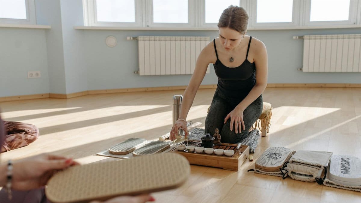 A serene tea ceremony involving a woman carefully pouring tea indoors, emphasizing mindfulness and wellbeing.