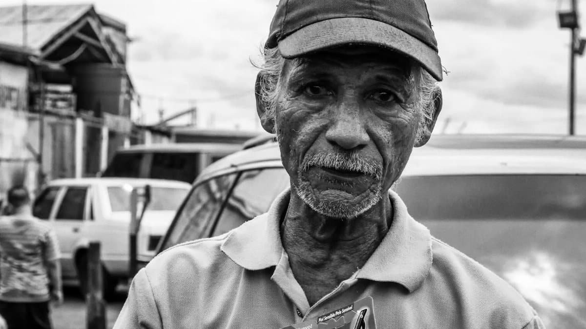 Black and white portrait of an elderly man selling products on the streets of Maracaibo, Venezuela.