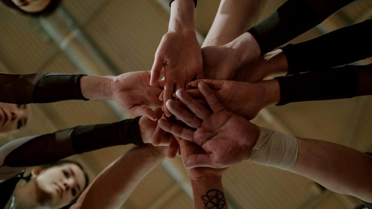 Group of people in a huddle showing unity and teamwork.