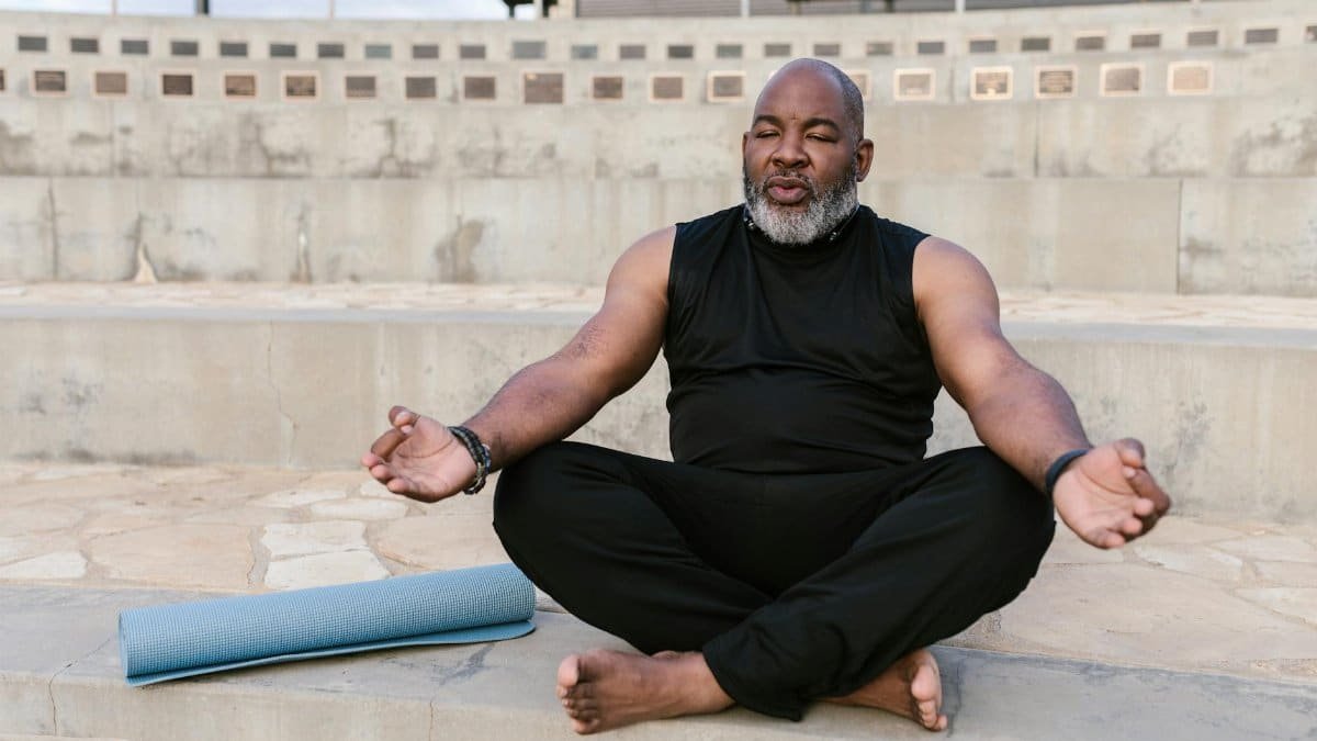 Senior man meditating outdoors promoting tranquility and wellness through yoga practice.