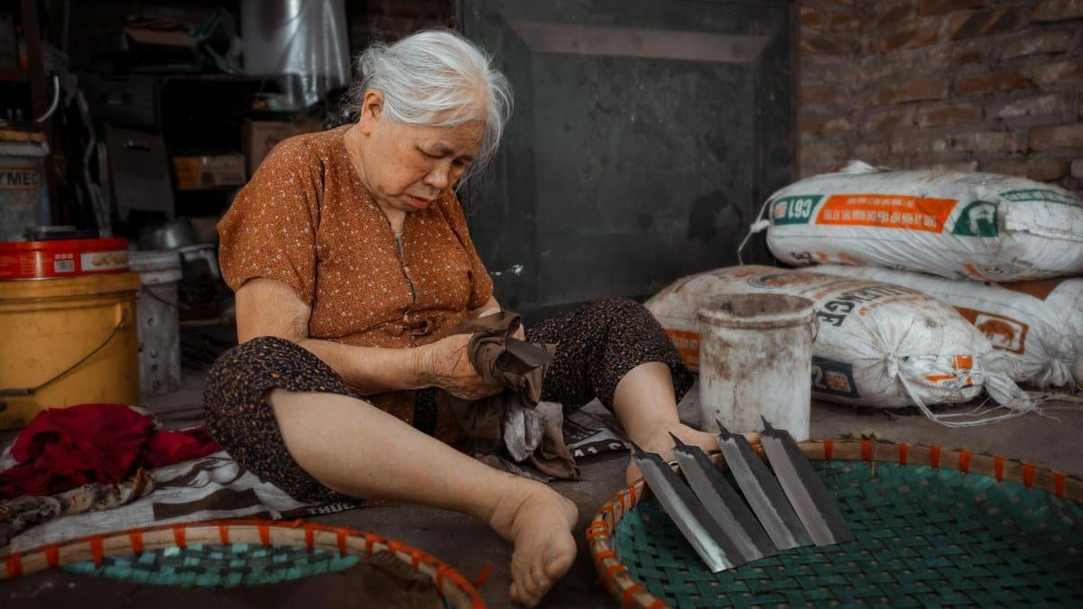 Senior woman working on craft indoors, showcasing traditional skill and dedication.