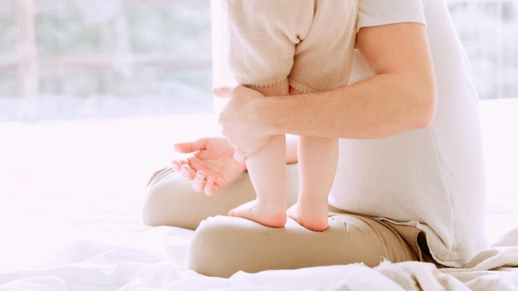 A father lovingly holds his baby, showcasing a moment of family bonding and affection.